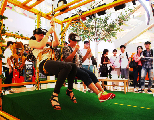 롯데자산개발이 서울 잠실 롯데월드몰 1층 아트리움에서 이색 놀이터 '미래야 놀자'를 선보였다. 28일 롯데월드몰에서 고객들이 가상현실(VR) 체험을 하고 있다. <롯데자산개발 제공>